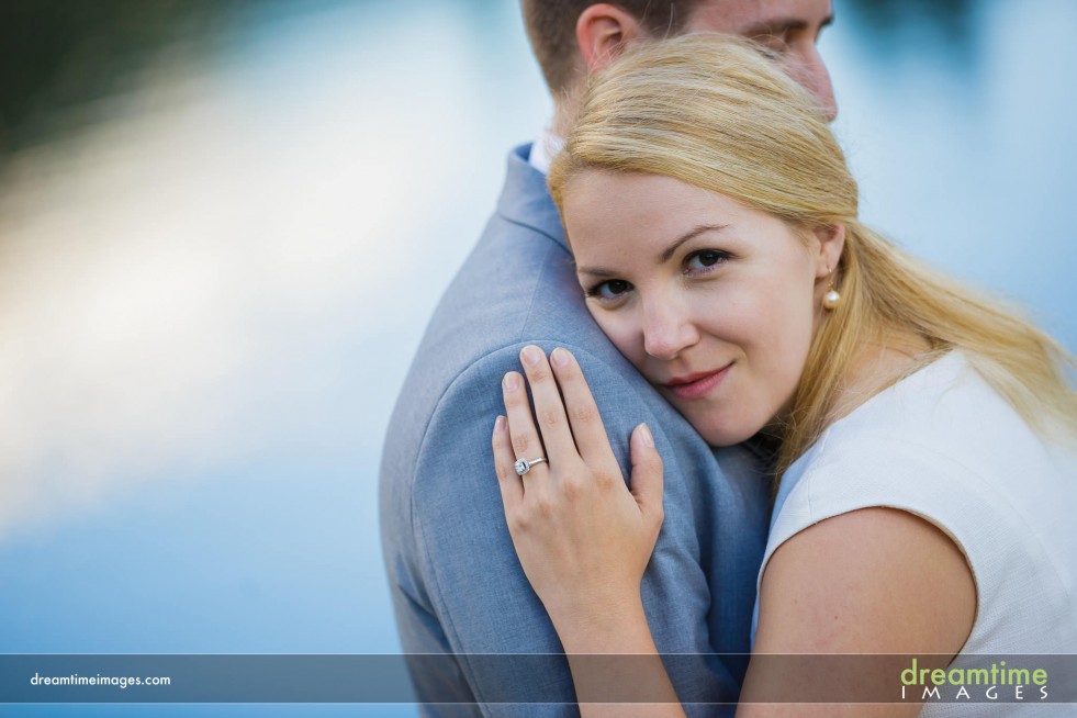 A bride looks into the camera during a hug